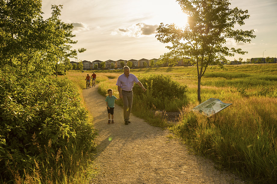 Grandpa and grandson walking on a trail on the Hydro Corridor in Sage Creek