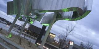 Sage Creek Village Centre Sculpture - The Aurora - reflective metal surfaces with green lighting