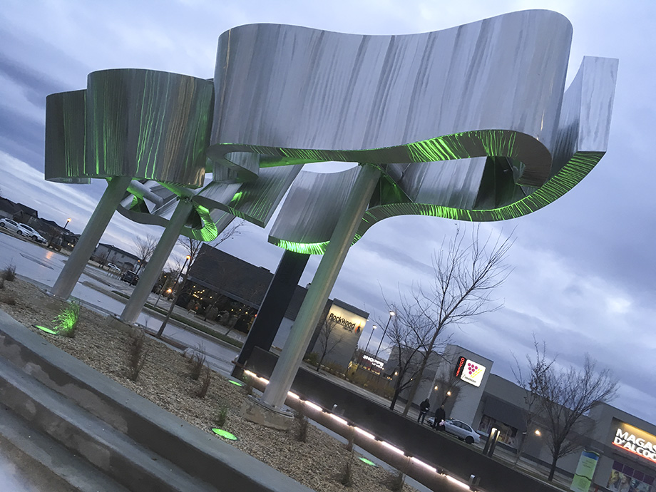Sage Creek Village Centre Sculpture - The Aurora - reflective metal surfaces with green lighting